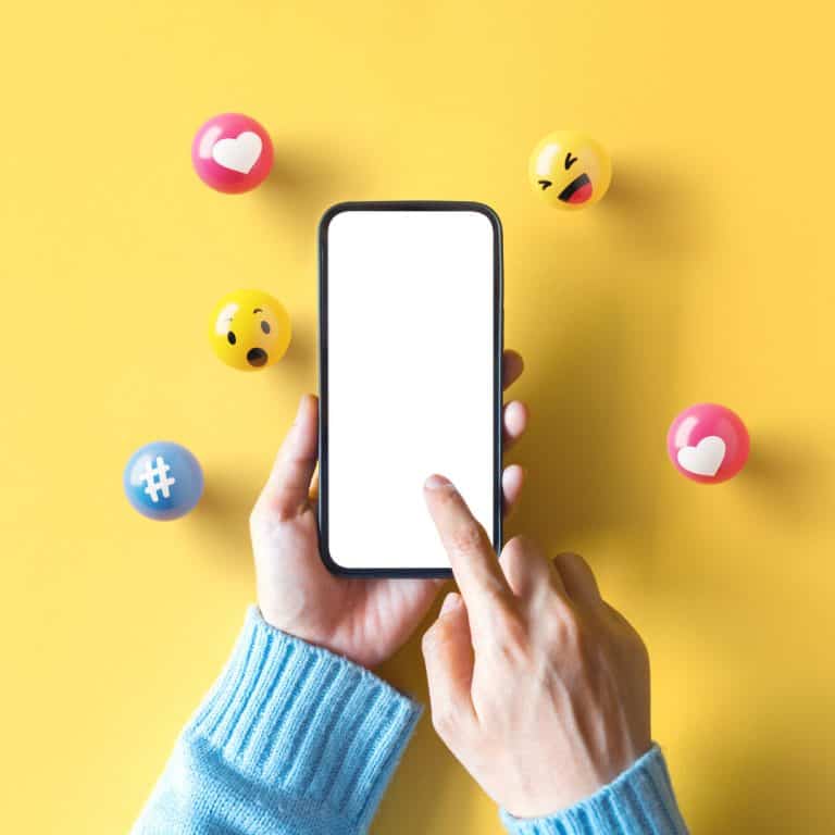 A picture of a finger swiping through a cellphone against a yellow background. This represent engaging in social media to support small businesses.